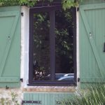 Fenêtre aluminium sur-mesure installée par LMA à Voinsles sur une maison aux volets verts.
