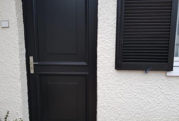 Porte d'entrée accompagnée de volets battants persiennes assortis, le tout conseillé, fourni et posé par D'Eco Ouest, votre installateur Solabaie