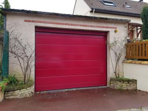 Porte de garage sectionnelle rouge posée sur une maison de la commune de Velizy-les-Bas par votre installateur-conseil D'Eco Ouest
