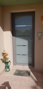 Porte d'entrée aluminium grise Grand vitrage modèle Baguio à vitrage feuilleté, installée par votre professionnel Solabaie ADECI.