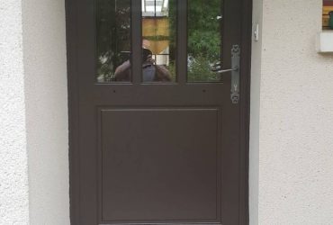 Porte d'entrée bois teintée d'un Brun Gris 8019 installée par ADECI